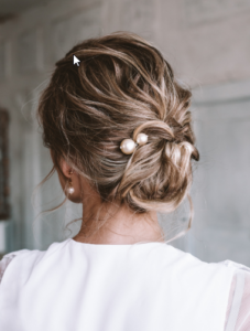 An older woman with an updo hairstyle looking from behind