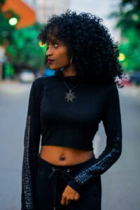 African-American woman with curly hair looking to the right. 